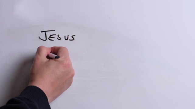 A person is writing Jesus Brings Hope in black marker pen on a whiteboard, perfect for Christian, religious themes, Church communications or faith presentations