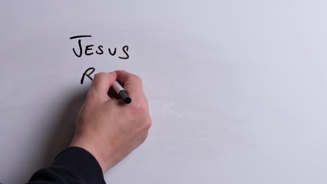 A person is writing Jesus Restores Souls in black marker pen on a whiteboard, perfect for Christian, religious themes, Church communications or faith presentations