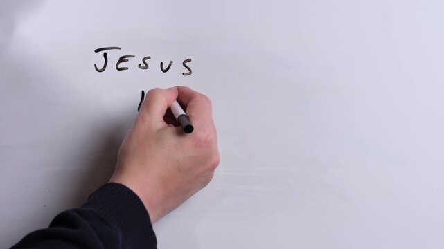 A person is writing Jesus is Truth in black marker pen on a whiteboard, perfect for Christian, religious themes, Church communications or faith presentations