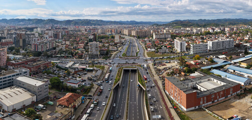 Obraz premium Panoramic aerial view of Tirana, Albania, showing multilane motorway and underpass along Dritan Hoxha Road with urban surroundings.
