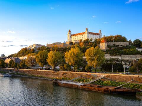 Bratislava Castle on a hill with autumn trees and Danube river