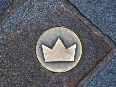 A series of bronze crowns embedded in the pavement that mark the route of the historical coronation procession of the Kingdom of Hungary