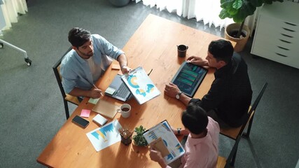 Top view of diverse business team talking and brainstorming marketing idea while colleague walking and joining meeting. Professional skilled people solving problem and looking at report. Convocation. - Powered by Adobe