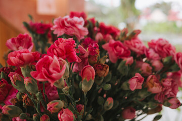 Pink spray roses with small buds in the interior of the living room close-up. Bouquets for home and comfort