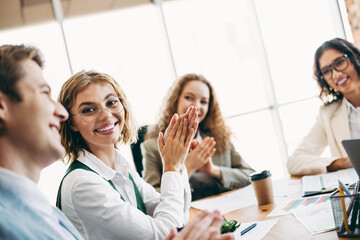 Group of professional colleagues seated together in a bright workspace engaged in a productive discussion and collaboration.