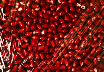 Juicy pomegranate seeds texture. plastic packaging