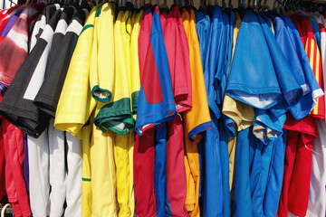 Viele bunte Trikots an einem Kleiderständer 