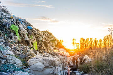 Sunset over a large garbage dump revealing the impact of waste on the environment in a remote area