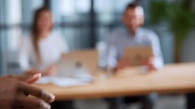 Handshake between diverse professionals indicates job offer acceptance in contemporary office interior. Bright environment with engaged colleagues