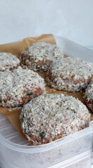 Homemade panko-crusted beef patties on tray with brown paper liner - concept of meal prep for butcher, restaurant, culinary school