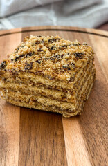 Delicious layered crumb cake on wooden board with copyspace: bakery, cafe, catering concept