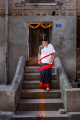 Nepali Newari Girl in Traditional Attire in Front of an Old House Door at Patan Durbar Square