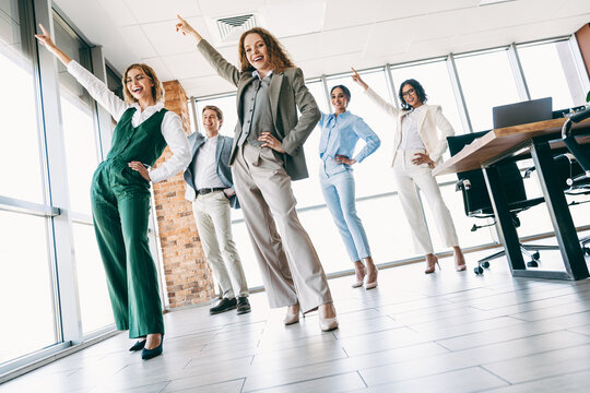 Confident business team celebrating success in a modern office workspace showcasing professionalism and teamwork