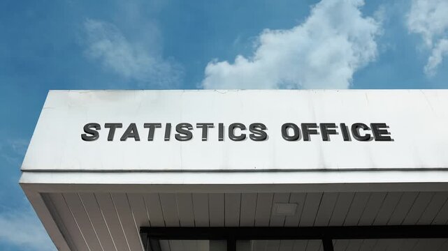 Statistics Office word sign displayed on a governmental or institutional building under a clear blue sky, symbolizing data analysis, research, official metrics, reporting, government, and quantitative