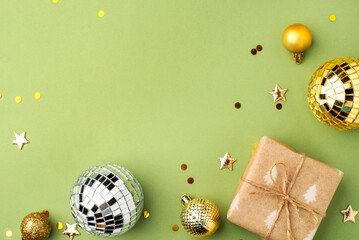 Christmas gift with gold ornaments on a green background.