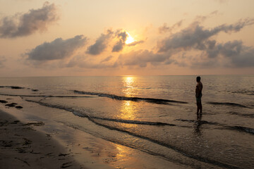 Man bathing on the beach at dawn.