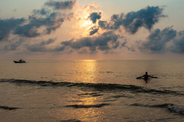 Man bathing on the beach at dawn.