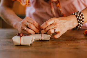 artisan wraps presents with warm glow, celebrating cozy moments through carefully wrapped holiday