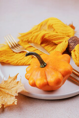 Autumn dinner plate with napkin and dry maple leaf