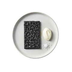 Flat lay of a gourmet black charcoal cracker with artisan textures, creamy crème fraîche, and sea salt on a white plate, isolated on transparent, high-key lighting. Concept of gourmet food elegance