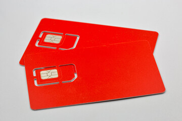 Two red SIM cards closeup on white background.