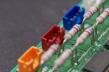 Close-up on circuit board showcasing resistors and colorful connectors, embodying technological precision and meticulous electronic design