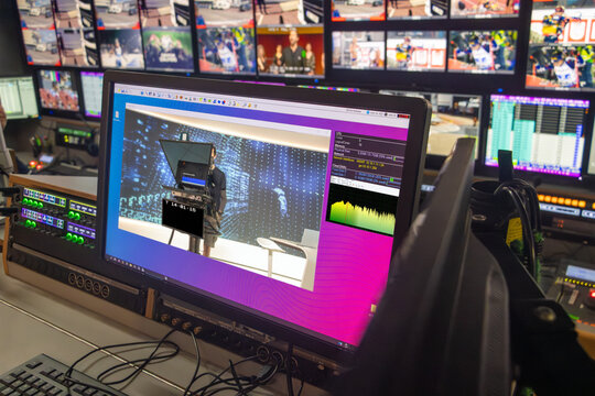 Busy broadcast control room with multiple screens - Powered by Adobe