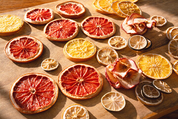 Various dried citrus fruits for winter and the christmas season. Sliced ​​dried fruits with apple rings on wood. Preparations for christmas celebrations.