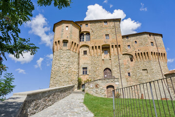 Low-angle view of the majestic Rocca Fregoso fortress in Sant'Agata Feltria, featuring massive brick bastions. © Marcel