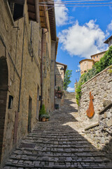 Steep, sunlit stone steps and alley in the historic town of Sant'Agata Feltria, Italy.