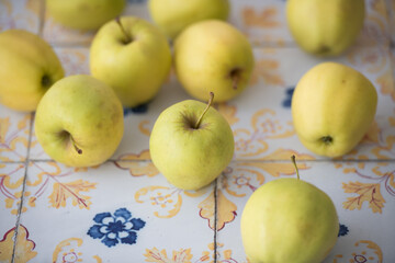 Group of apples arranged on vintage tiles, great for cookbook covers, restaurant menus, or natural product advertisements.