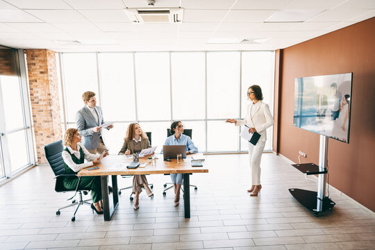Professional business team in a collaborative meeting discussing projects and strategies in a modern office workspace