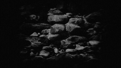 Stones underwater, grainy background in a dark frame.
