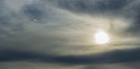 Dark gray and smoky clouds obscure the morning sun.