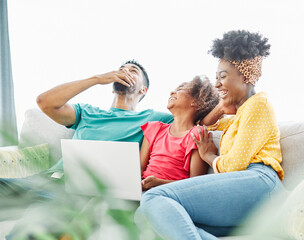 Mother, father and daughter doing homework with laptop at home. Mom, dad and teenage black girl happy using laptop. Teen girl and parents sitting at home working with notebook