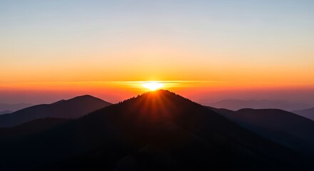 Golden sunrise bursting over dark mountain peaks creating a dramatic and vibrant sky gradient