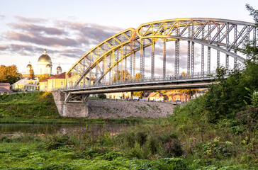 Steel arch bridge across the Msta river in summer evening. Built in 1905. Borovichi, Russia