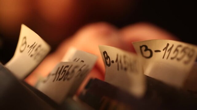 A close-up shot shows a hand pulling a file folder marked "5-22537" from a row of indexed archaeological documents on a dark library shelf.