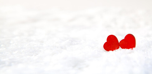 Two red hearts on white snow background. Valentines day concept.