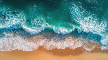 Obraz premium Aerial view of ocean wave crashing on sandy beach with white foam
