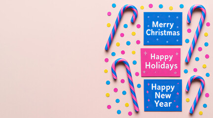 Colorful greeting cards and candy canes on pastel background