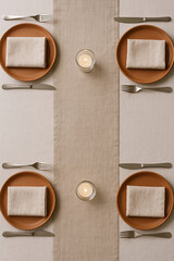 Minimal holiday table setting with candles and linen napkins