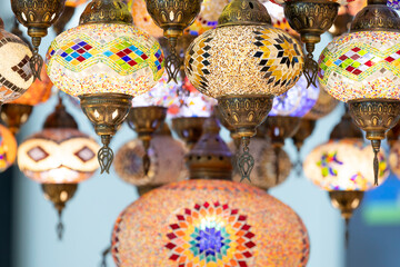 A large number of oriental lamps hang together suspended from the ceiling.