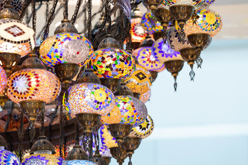 A large number of oriental lamps hang together suspended from the ceiling.