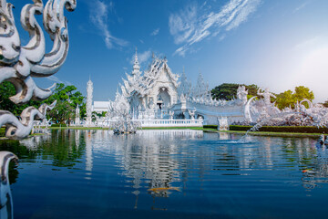 Stunning white temple wat rong khun reflecting in water at Chiang Rai, Thailand