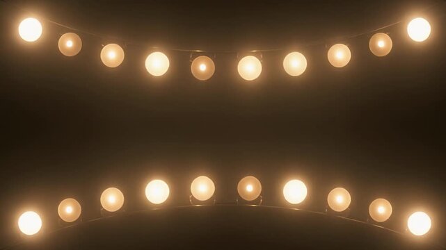 Two rows of illuminated incandescent light bulbs strung across a dark, textured background creating a festive or theatrical atmosphere