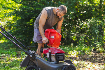 Man pours gasoline into lawnmower