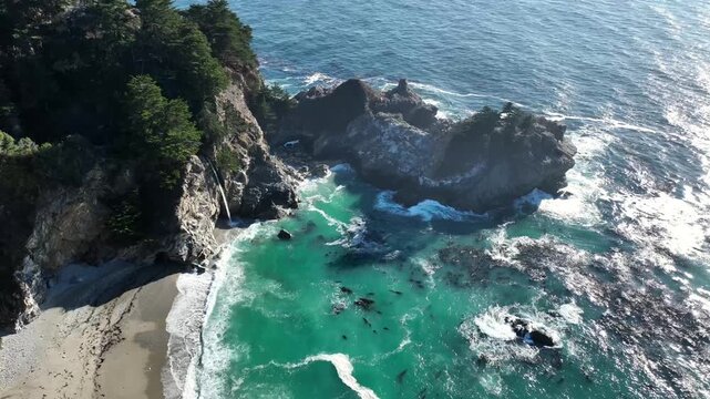 Big Sur, CA - Drone View of McWay Falls Flowing into the Turquoise Waters of the Pacific Ocean at Julia Pfeiffer Burns State Park in Big Sur, California &ndash; Iconic Coastal Landscape with Rocky Cliffs