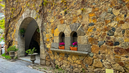 Timeless Stone Archway: A captivating view of an ancient stone archway adorned with climbing vines, intricate stone windows and the subtle touch of greenery and floral arrangements.