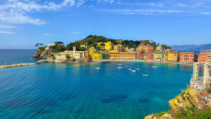 Picturesque Coastal Village: A vibrant coastal village, nestled along the azure shoreline, showcases a kaleidoscope of colorful buildings under a clear, cloudless sky.